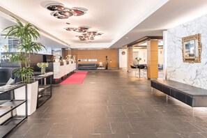 A modern lobby with a reception desk, seating area, and a marble wall. - Radisson Blu Plaza Hotel, Helsinki (Helsinki)