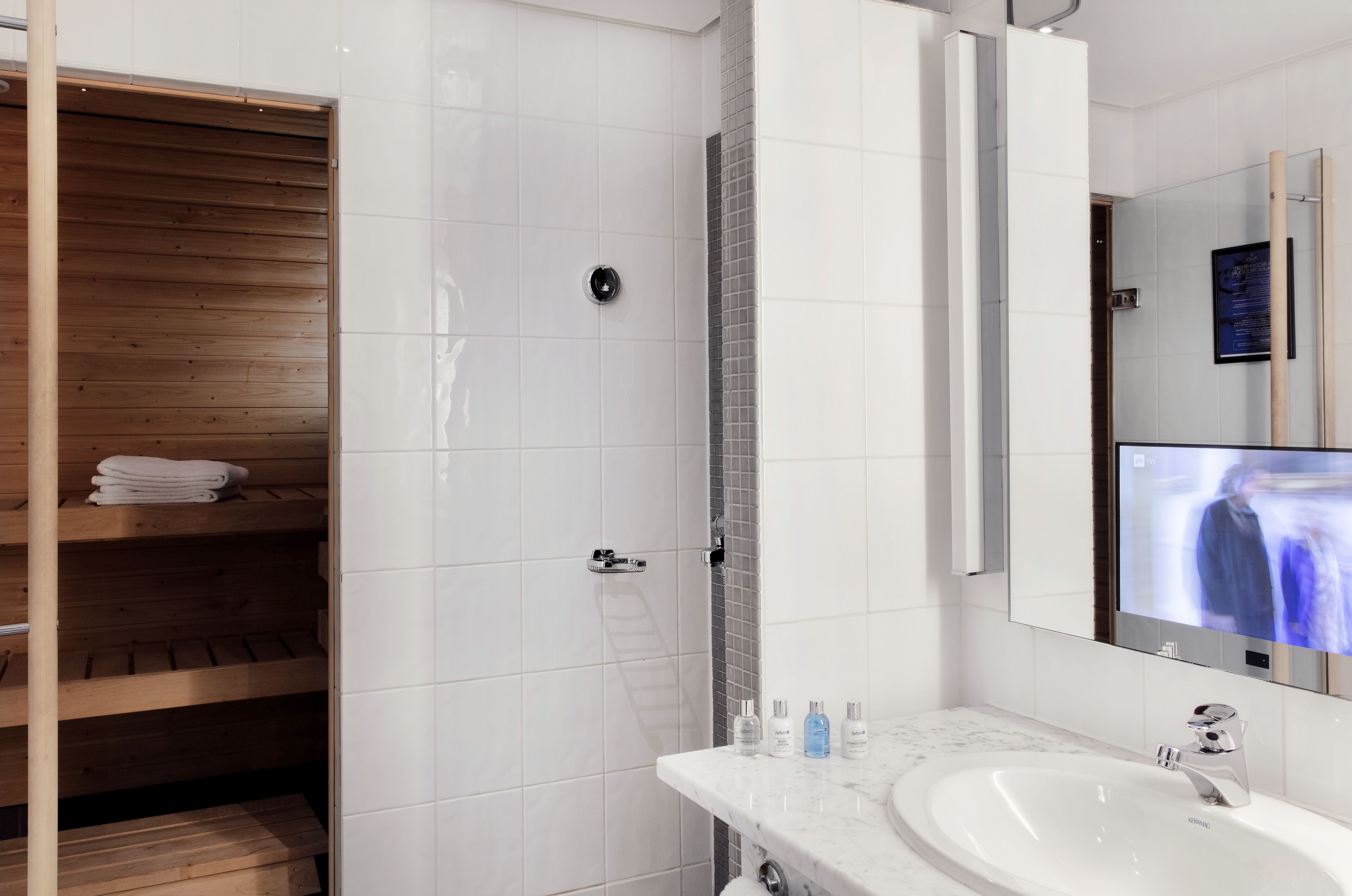 Un baño moderno con cabina de ducha de madera, un espejo grande y un lavamanos de mármol.