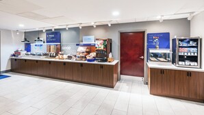 A modern breakfast area with a counter displaying various food items and a refrigerated display case. - Holiday Inn Express Breaux Bridge by IHG (Breaux Bridge)