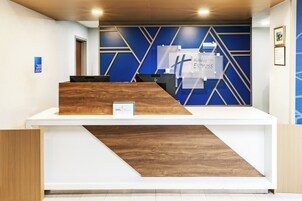 Uma receção com design de parede geométrico azul e detalhes em madeira.