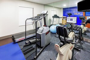 A gym with treadmills, a stationary bike, and free weights.