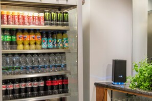 Un frigorifero per bevande pieno di diverse marche, tra cui Costa, Fanta e Monster energy drink.