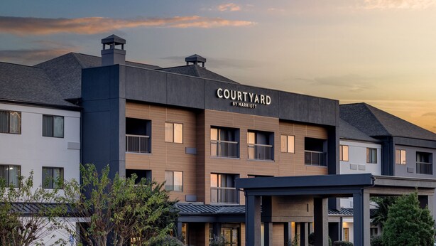 A multi-story hotel with a modern design, featuring a courtyard and a sign that reads "COURTYARD BY MARRIOTT". - Courtyard by Marriott Shreveport Airport (Shreveport)