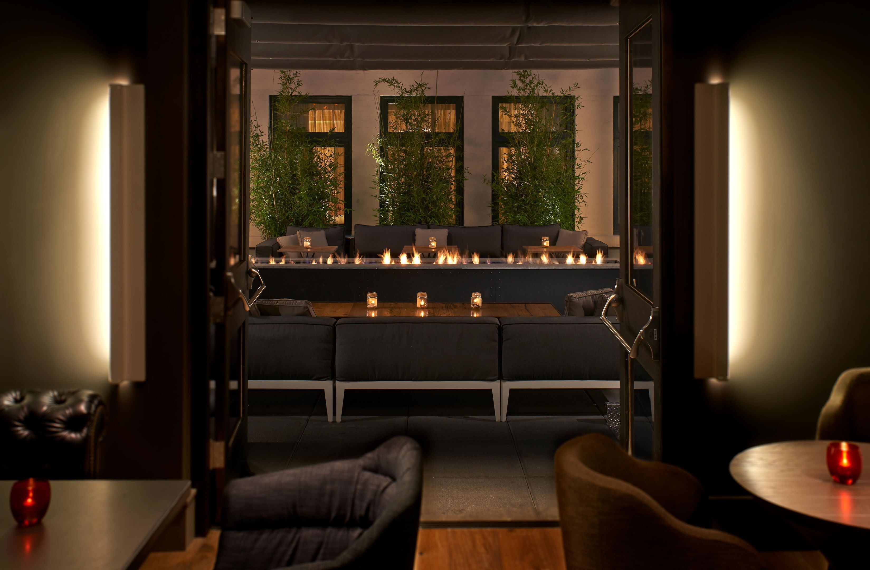 A modern interior with a sofa, tables, and candles.