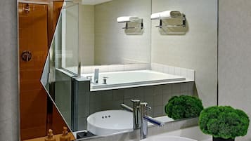 Een moderne badkamer met een grote spiegel, een wit wastafelmeubel en twee groene, bolvormige decoraties.