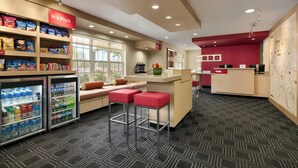 A hotel lobby with vending machines, a reception desk, and seating areas. - TownePlace Suites by Marriott Gaithersburg (Gaithersburg)