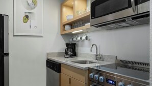 Una cocina moderna equipada con lavavajillas, estufa, microondas y cafetera.
