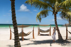 A beach with hammocks and palm trees. - Dusit Ajman Resort & Villas (Ajman)
