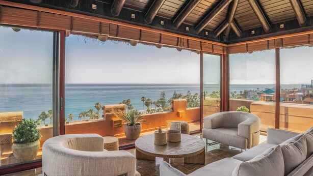 A spacious balcony with a view of the ocean, furnished with a sofa, chairs, and a coffee table. - Hacienda del Mar member of Meliá Collection (Estepona)