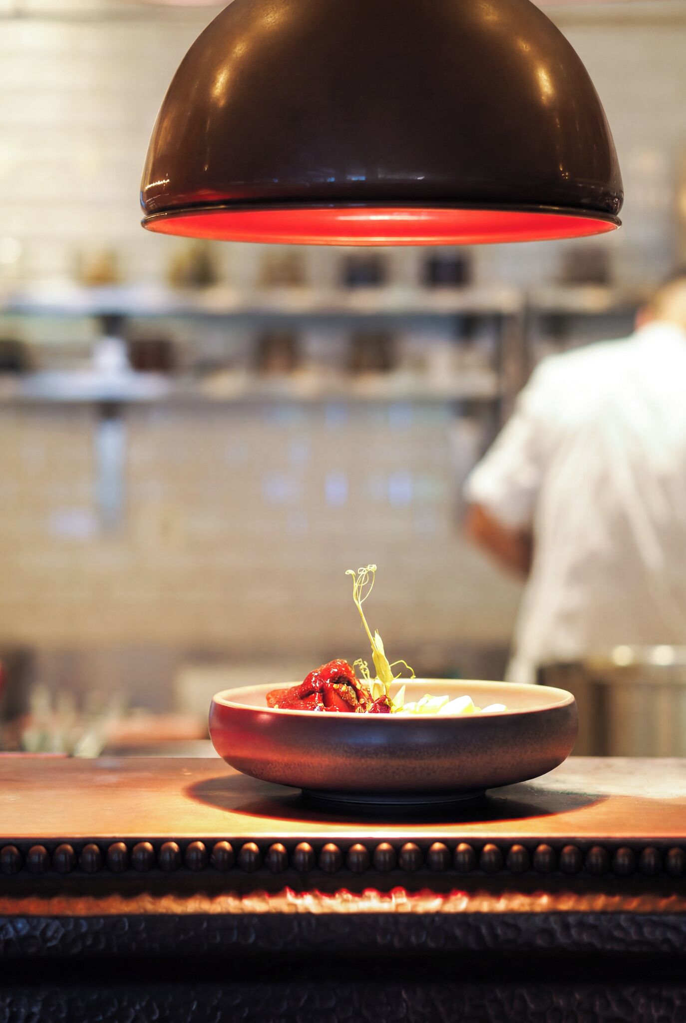 A restaurant setting with a dish on a table under a red light.