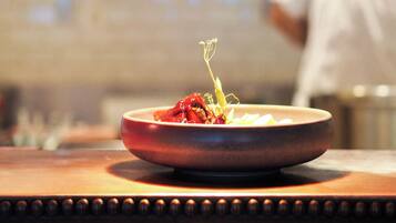 A restaurant setting with a dish on a table under a red light.