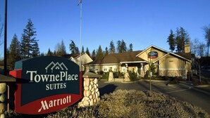 Enseigne de l’hôtel TownePlace Suites Marriott, avec un pilier en pierre et un bâtiment en arrière-plan.