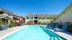 Une piscine avec des chaises longues et un espace de détente abrité.