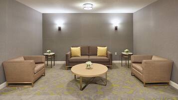 A modern living room with a brown sofa, two side tables, and a round coffee table.