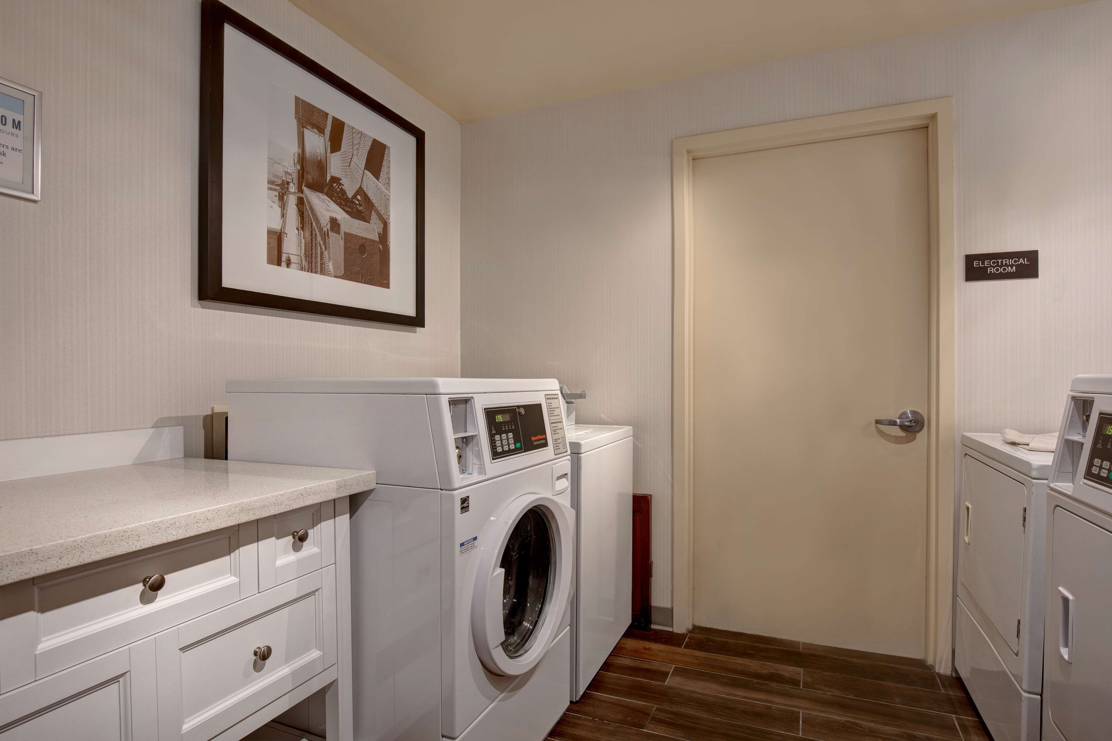 A laundry room with a washing machine, dryer, and a door labeled "ELECTRICAL ROOM".