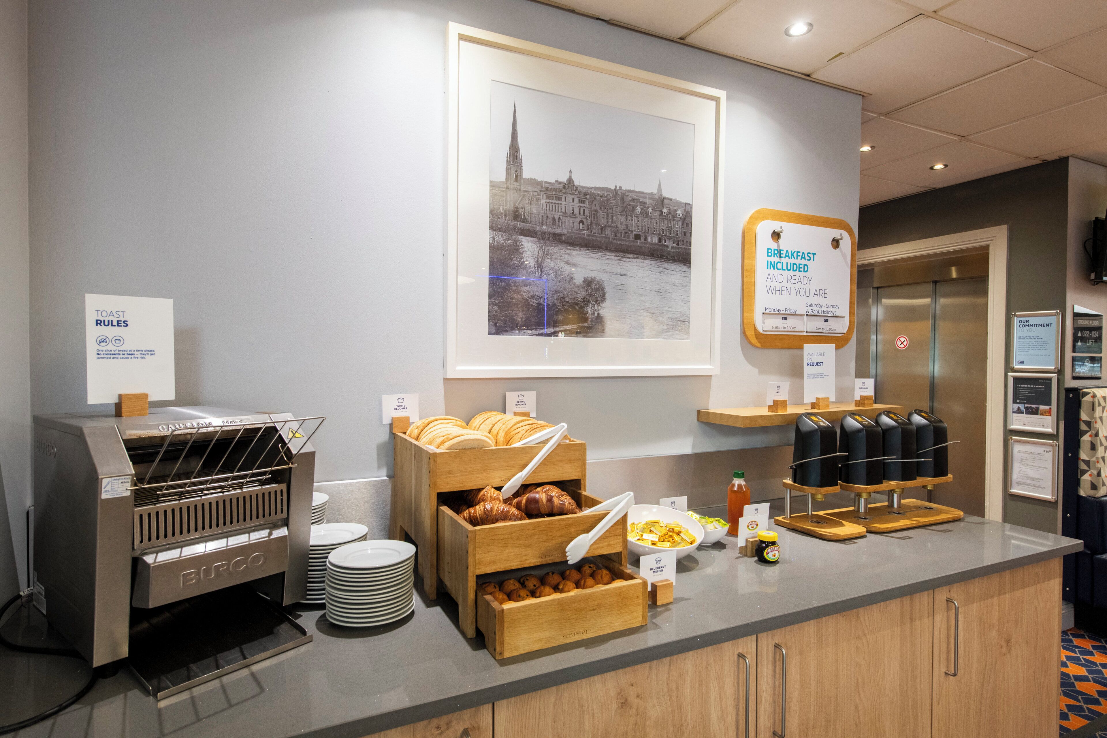 Un ricco buffet per la colazione con croissant, dolci e macchine per il caffè.