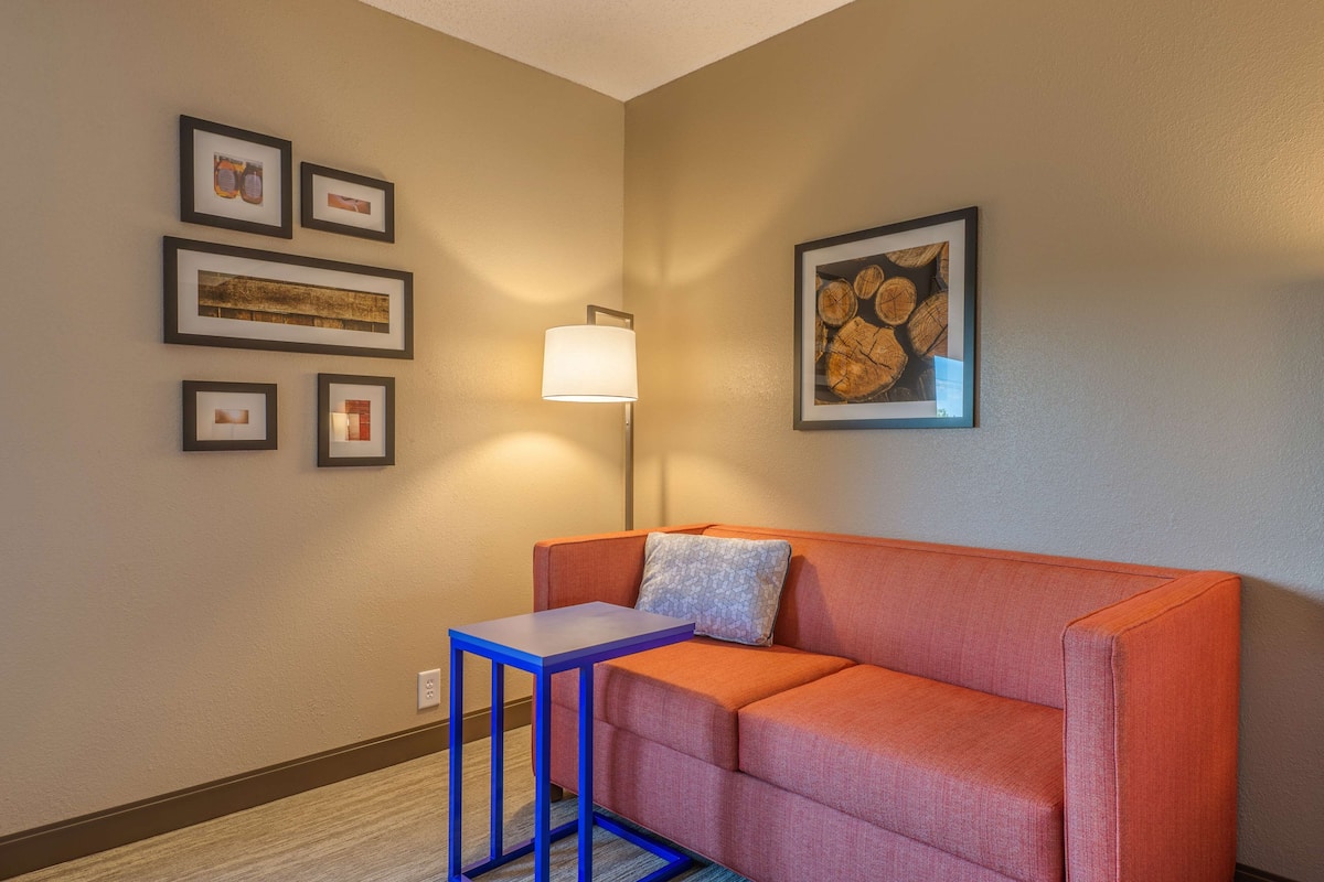 A room with a sofa, a small table, and framed pictures on the wall.
