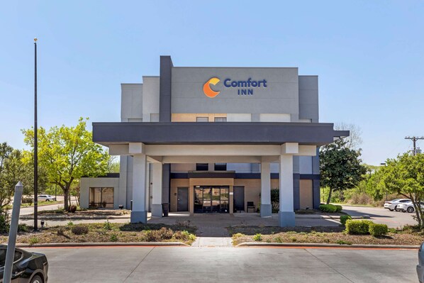 A Comfort Inn hotel with a modern design, featuring a prominent logo and a well-maintained entrance area. - Comfort Inn Sherman - Denison Area (Sherman)