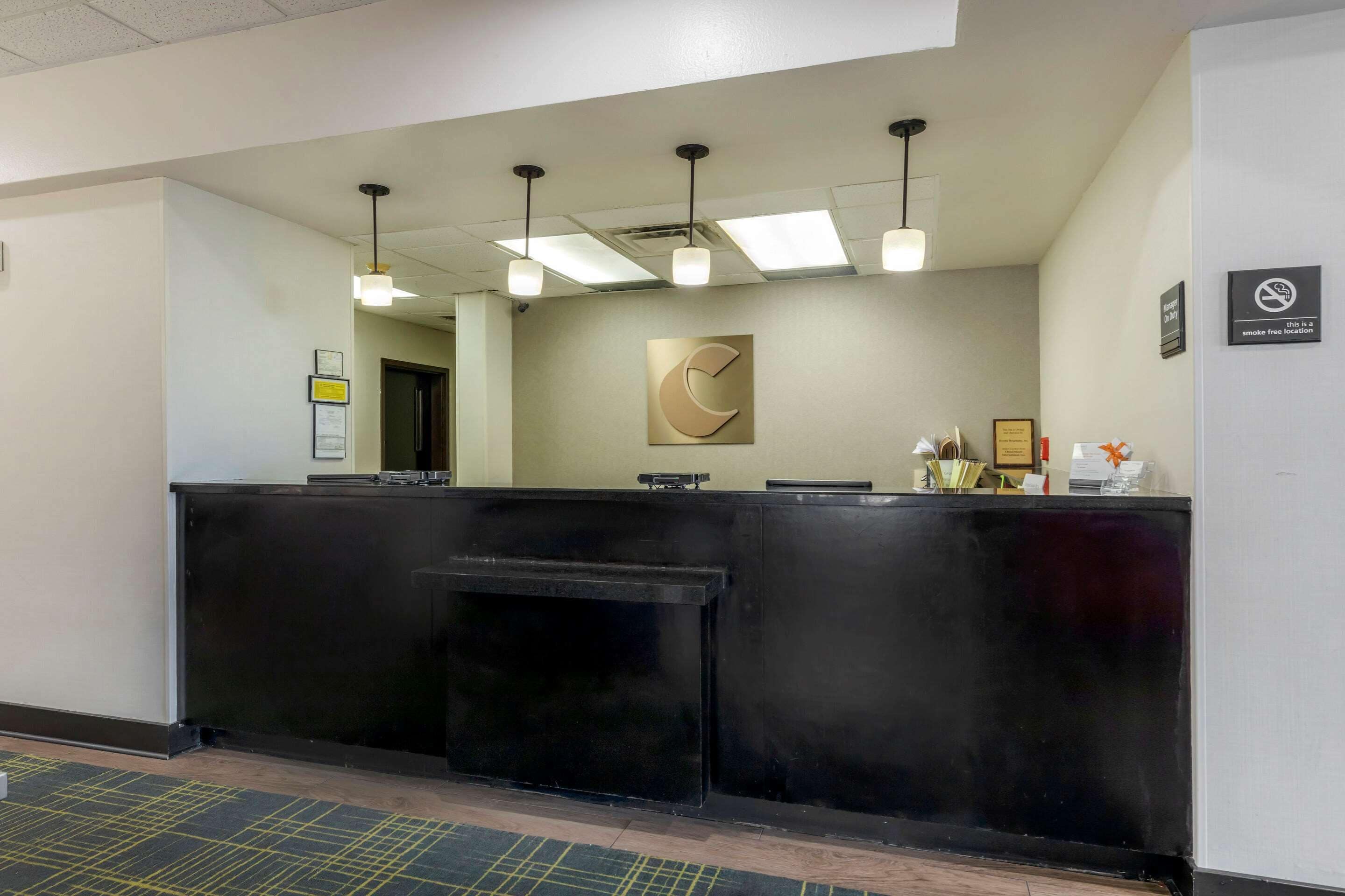 A reception area with a black counter, a framed artwork, and a smoke-free sign.