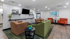A modern waiting area with seating, a TV, and artwork on the walls.
