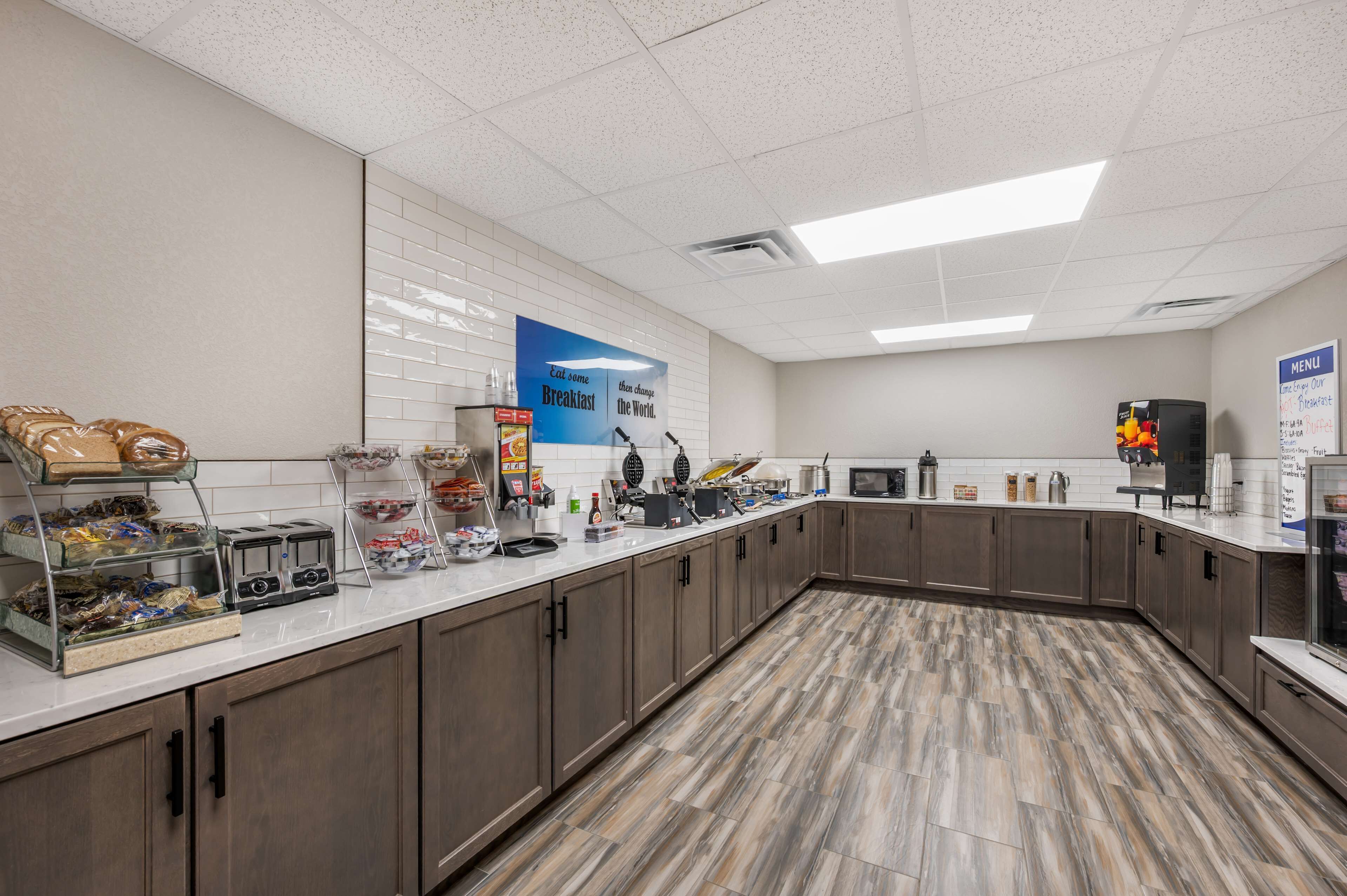 A breakfast area with a counter, food display, and a menu sign.