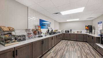 A breakfast area with a counter, food display, and a menu sign.