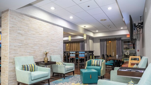 A hotel lobby with seating areas, a reception desk, and a dining area. - Hampton Inn St. Augustine-I-95 (St. Augustine)