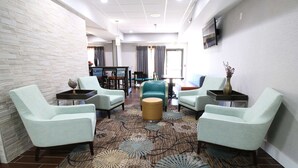 A hotel lobby with light-colored chairs, a round table, and a patterned carpet. - Hampton Inn St. Augustine-I-95 (St. Augustine)
