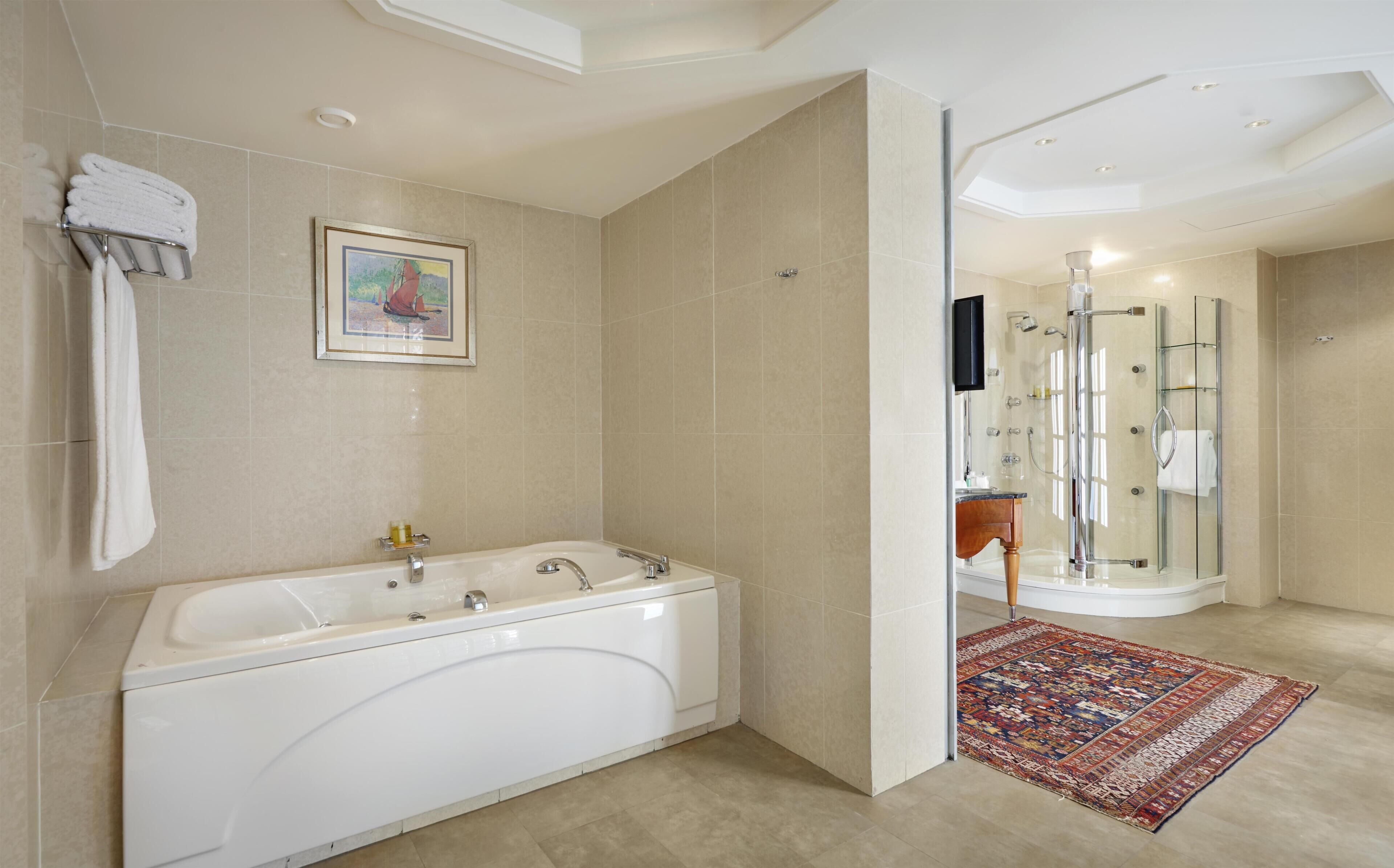 A modern bathroom with a freestanding bathtub, a glass-enclosed shower, and a tiled floor.