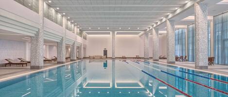 Alberca techada, alberca al aire libre y sombrillas en la alberca