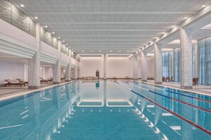 Alberca techada, alberca al aire libre y sombrillas en la alberca