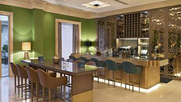 A modern bar area with a bar counter, stools, and a wine rack.