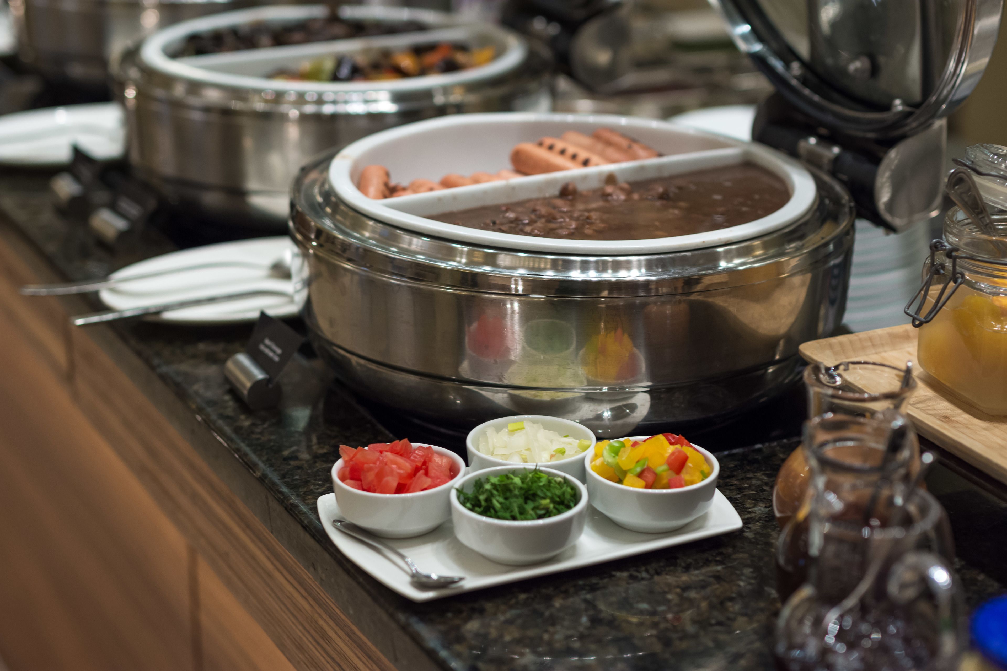 A buffet setup with various food items and condiments.
