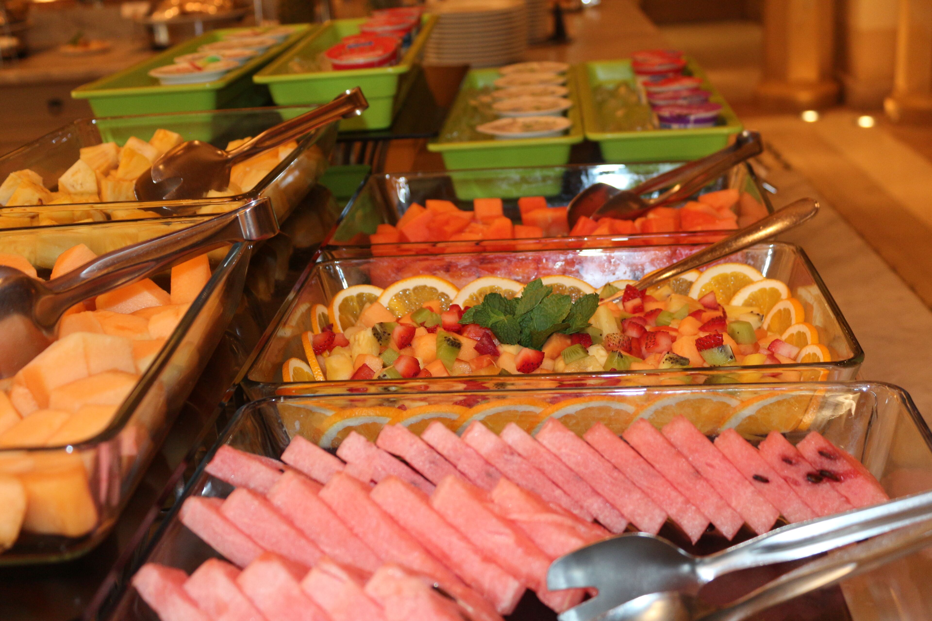 Un buffet proposant une variété d’aliments, notamment des fruits, des légumes et des viandes.