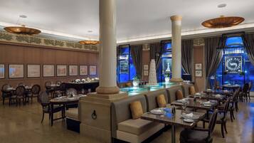 A spacious restaurant with high ceilings, large columns, and a central bar area.