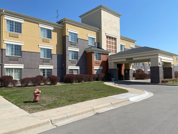 Hotel building with a modern design, featuring large windows and a covered entrance.