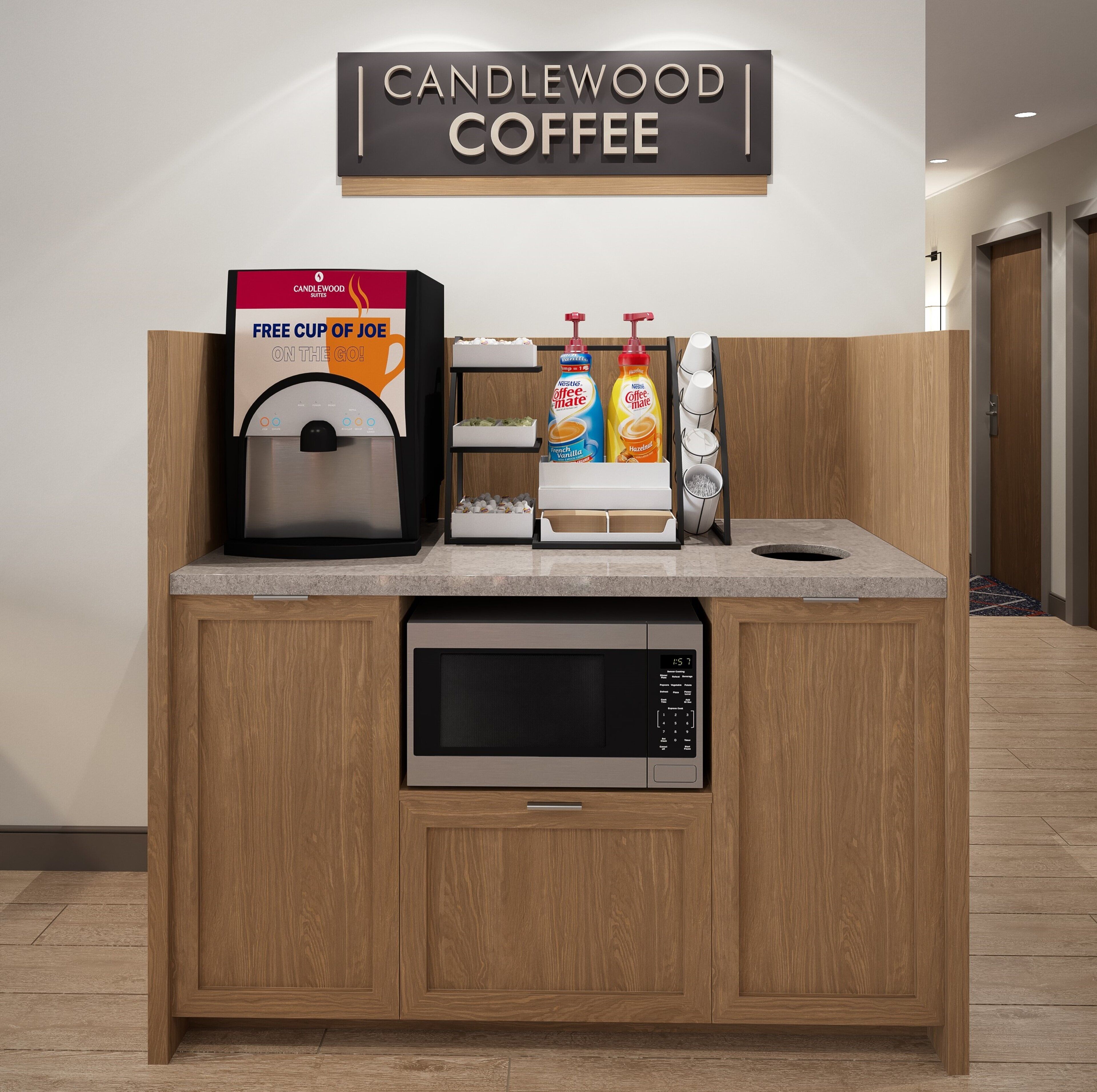 A coffee station with a coffee machine, a sign reading "CANDLEWOOD COFFEE", and a free cup offer.