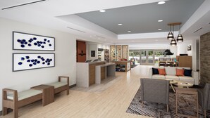 A modern hotel lobby with a reception desk, seating area, and a large window offering a view of the outdoors. - Candlewood Suites Beachwood Cleveland by IHG (Beachwood)