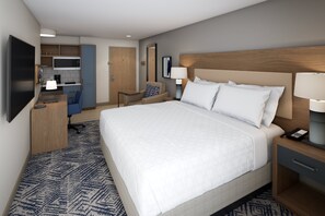 A hotel room with a large bed, a desk with a chair, a kitchenette, and a TV. - Candlewood Suites Beachwood Cleveland by IHG (Beachwood)