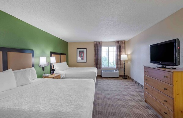 A hotel room with two beds, a television, a dresser, a window with curtains, and a framed picture on the wall. - Extended Stay America Suites Los Angeles Glendale (Glendale)