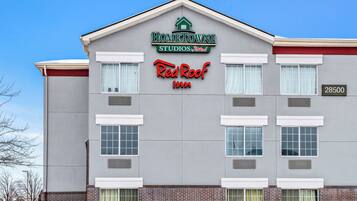 A building with a sign for "HOMETOWNE STUDIOS Red Roof Inn" and the address "28500".