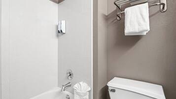 A bathroom with a bathtub, a toilet, and a towel rack.