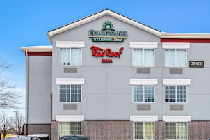 Un edificio con un letrero que dice "HOMETOWNE STUDIOS Red Roof Inn" y la dirección "28500".