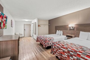 Una habitación de hotel con dos camas, un escritorio y un televisor.