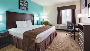 Une chambre d’hôtel avec un grand lit, deux tables de chevet, un bureau, une chaise et une fenêtre avec des rideaux.