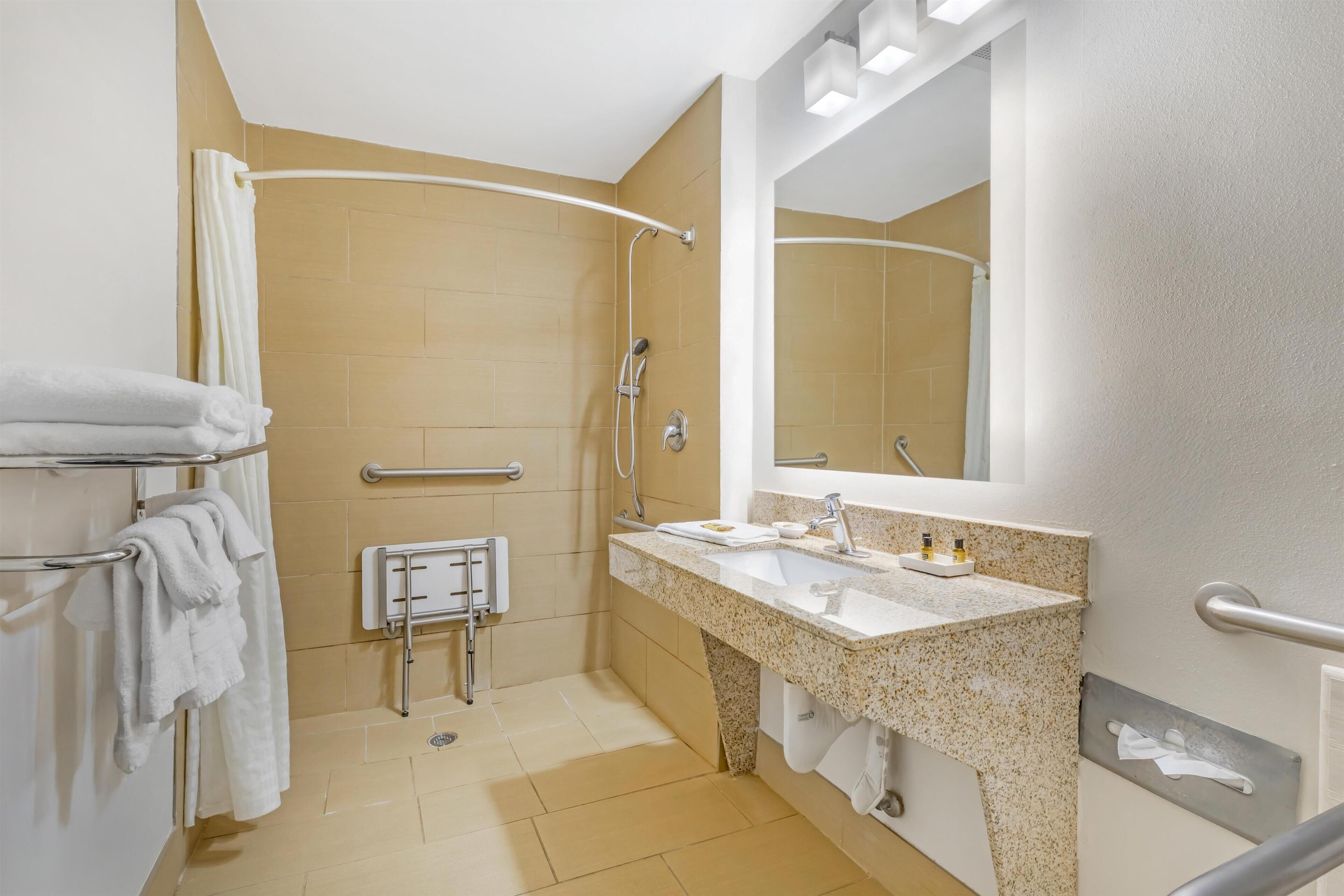 Ein modernes Badezimmer mit Dusche, Waschbecken und Spiegel.