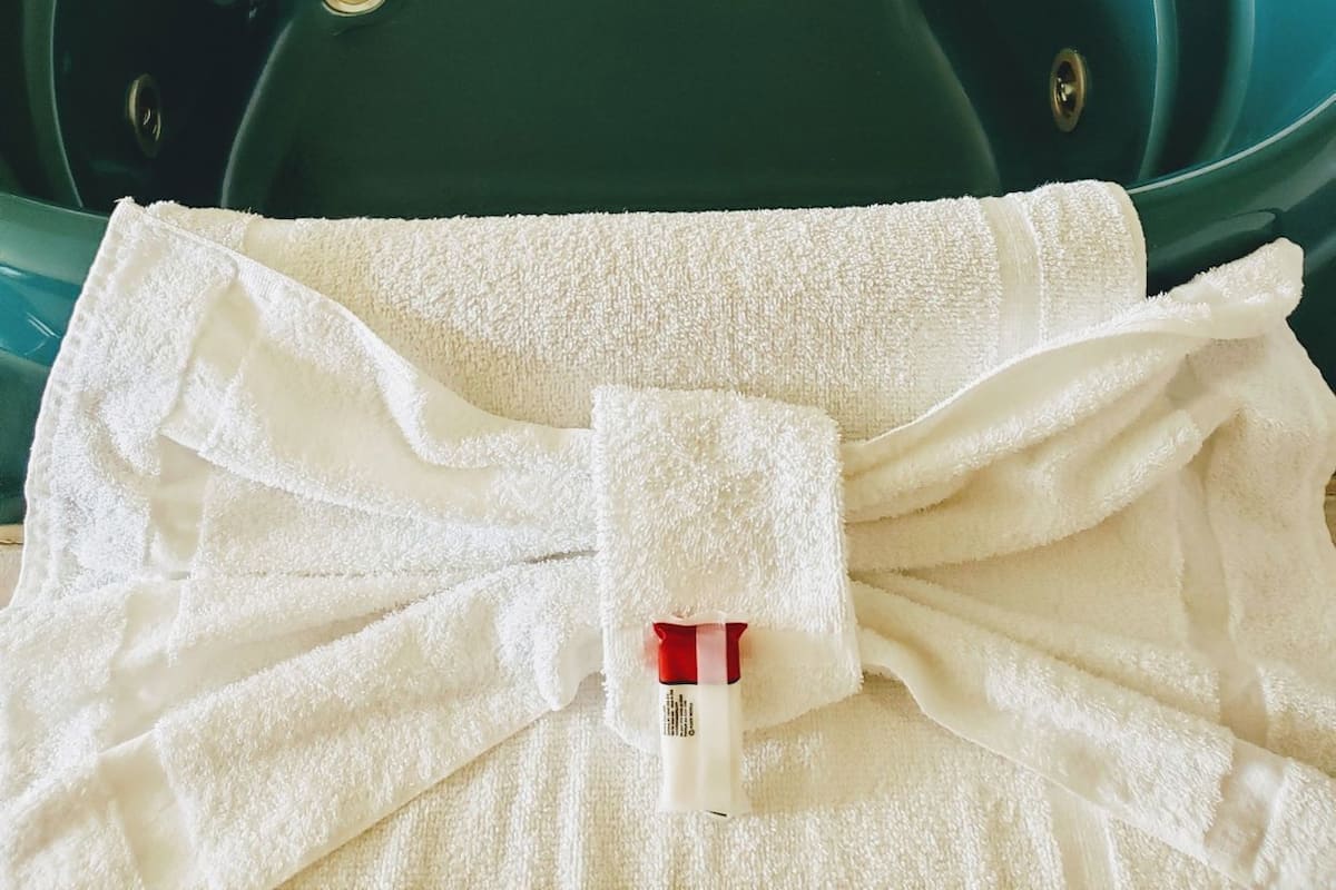 Una bañera verde con un grifo y una toalla al frente.