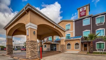 Experience the grand entrance of this Best Western Plus hotel, featuring a striking arched overhang and stone pillars.