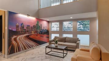 Uma sala de estar moderna com um mural de paisagem urbana, um sofá, uma mesa de centro e grandes janelas.