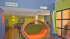 Una habitación con un sillón colgante circular, televisión y un mostrador de recepción.